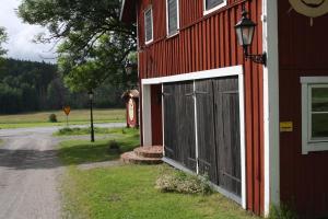 een rode schuur met een deur aan de zijkant bij Ladugårdens Pub & Sal in Enhörna