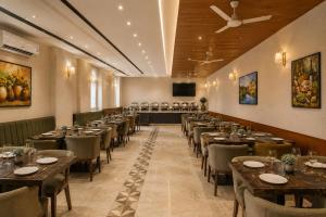a conference room with tables and chairs and a screen at Hotel Luxury Inn Delhi Airport in New Delhi
