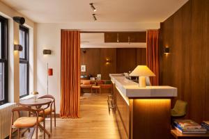 eine Küche mit orangefarbenen Vorhängen, einem Tisch und Stühlen in der Unterkunft Le Berger Latroupe Hotel in Brüssel