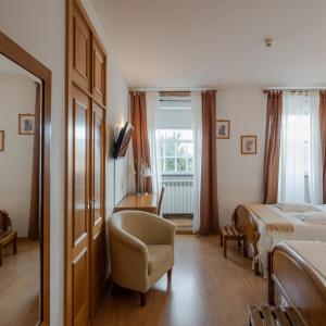 a bedroom with a bed and a chair and a window at Hotel Santos in Guarda