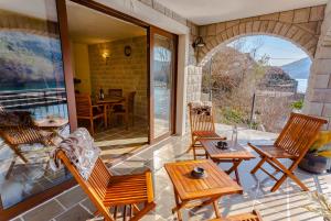a patio with rocking chairs and a table and a table at "Paradise Lake House" at National Park Skadar Lake in Karuč