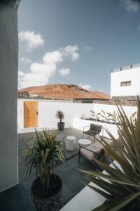 a patio with potted plants and a white wall at Finca Marisa in Tinajo