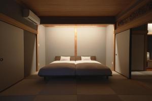 a bedroom with a large bed with white sheets at Hakusyu - Vacation STAY 11460v in Aso