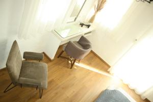 アスティパレア・タウンにあるTholaria Boutique Hotelの椅子2脚、洗面台、鏡が備わる客室です。