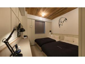 a room with two beds and a television in it at Kamon Hotel Namba - Vacation STAY 37029v in Osaka +11 photos