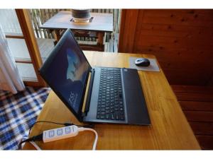 a laptop computer sitting on top of a wooden table at Cottage Izu,com - Vacation STAY 07073v in Minamiizu