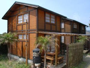 a wooden house with palm trees in front of it at Cottage Izu,com - Vacation STAY 07073v in Minamiizu