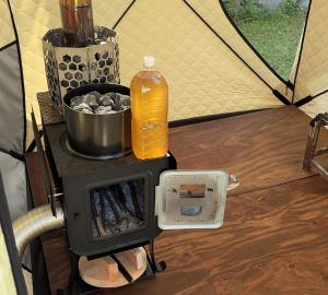 a stove in a tent with a bottle of orange juice at Cottage Izu,com - Vacation STAY 07073v in Minamiizu