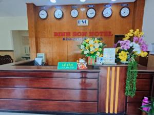 a reception desk with clocks on the wall at Bình Sơn Hotel - Khách sạn tại Dung Quất in Bình Sơn