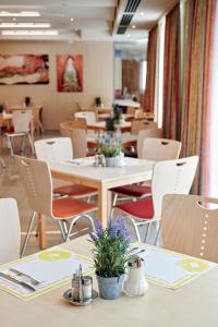 a restaurant with tables and chairs with flowers on them at Hotel Kolping Wien Zentral in Vienna