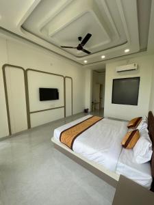 a bedroom with a bed and a ceiling fan at Marudhar Resort in Chittaurgarh +14 photos