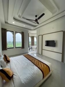 a bedroom with a large bed and a flat screen tv at Marudhar Resort in Chittaurgarh