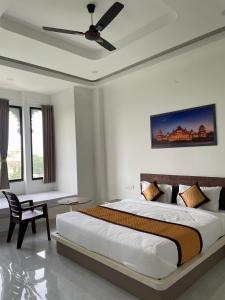 a bedroom with a large bed with a ceiling fan at Marudhar Resort in Chittaurgarh