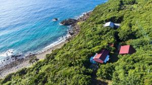 an aerial view of a house on a hill next to the ocean at Hide A Way - Vacation STAY 90104v in Nishinoomote