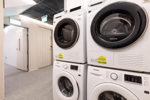 two washing machines and a dryer in a laundry room at Heritage Collection on KG - Mobile App Check-In in Singapore