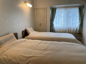 two beds in a room with a window at Lavender - Vacation STAY 26426v in Nishina