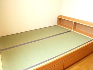 a bedroom with a bed with a wooden frame at Anan Station Hotel - Vacation STAY 11048v in Anan +8 photos