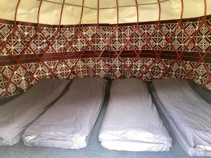 a bed with three white pillows under a canopy at Kerben Yurt Camp Arashan in Mineralʼnyy Istochnik Altyn-Arasan