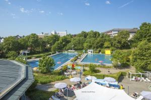 an overhead view of a swimming pool with umbrellas at EifelLandhaus in Biersdorf am See