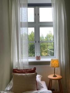 a bedroom with a window and a bed and a lamp at Roholtegaard in Faxe