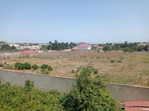 a view of a field with a farm in the background at Esco Hostel in Nardaran
