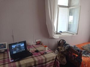 a laptop computer sitting on a table in a bedroom at Esco Hostel in Nardaran