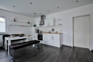 ターレにあるFerienwohnung im Bockrießの白いキャビネットと黒いベンチ付きのキッチンが備わります。