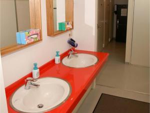 a red bathroom counter with two sinks and a mirror at Hostel Zen - Vacation STAY 91871v in Yokohama +13 photos