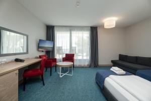 a hotel room with a bed and a desk and chairs at Hotel Skipper in Rewa