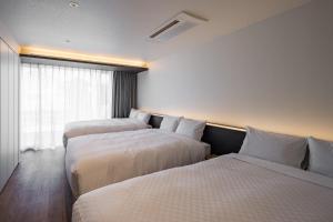 a hotel room with three beds and a window at Hotel Dios - Vacation STAY 31239v in Awaji +17 photos