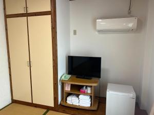 a room with a television and a small table with towels at Hotel Yamadaso - Vacation STAY 41349v in Nago