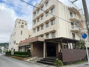 a large white building on the side of a street at Hotel Yamadaso - Vacation STAY 41344v in Nago