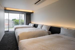 two beds in a room with a window at Hotel Dios - Vacation STAY 31184v in Awaji