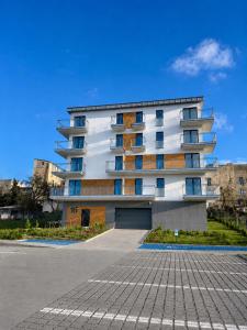 a building with a parking lot in front of it at Apartament Tarasy Wenecji 2 in Gniezno