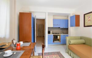 a kitchen and living room with blue cabinets and a table at Rasara in Arquà Petrarca