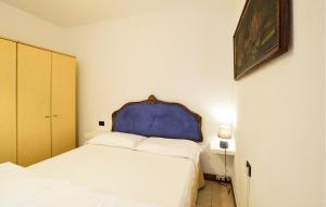 a bedroom with two beds and a blue headboard at Rasara in Arquà Petrarca