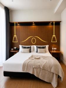 a bedroom with a large bed with three lights above it at Legazpi Doce Rooms & Suites in San Sebastián
