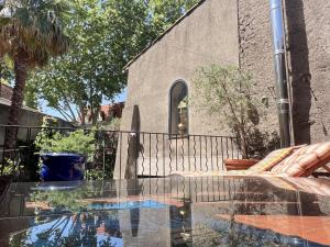 a patio with a glass table in front of a church at Maison malouna in Saint-Thibéry