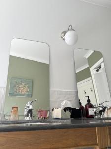 a bathroom counter with a mirror and a sink at Maison malouna in Saint-Thibéry