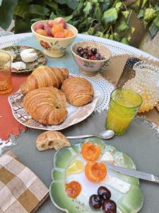 a table with a plate of pastries and bowls of fruit at Maison malouna in Saint-Thibéry