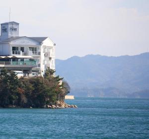 a large white house on a island in the water at Hotel Mare - Vacation STAY 24956v in Kure