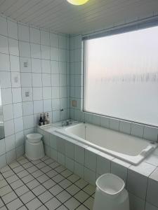 a white bathroom with a tub and a toilet at Hotel Mare - Vacation STAY 58144v in Kure
