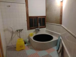 a bathroom with a tub in the middle of a room at Setouchi base - Vacation STAY 48143v in Mitoyo