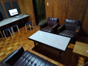 a waiting room with leather chairs and a table at Setouchi base - Vacation STAY 48143v in Mitoyo