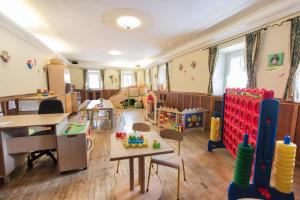 ein Kindergarten-Klassenzimmer mit Tischen, Stühlen und Spielzeug in der Unterkunft Ferienhaus/Chalet Schneiderhäusl in Flachau