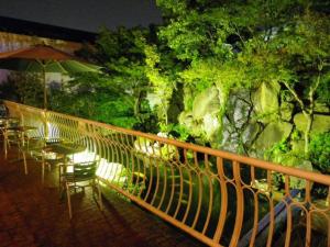 a balcony with tables and chairs and an umbrella at HOTEL SEAGULL - Vacation STAY 86796v in Izumi-Sano