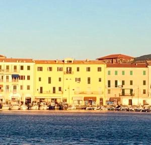 a large building next to a body of water at Le Stanze sul Mare in Portoferraio