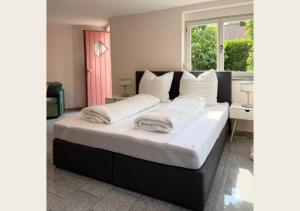 a bedroom with a large bed with white pillows at hortensiengarten in Teningen