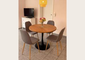 a dining room table with chairs and a vase of flowers at hortensiengarten in Teningen