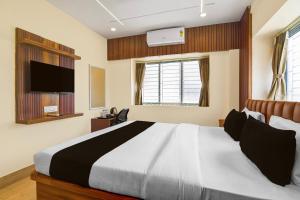 a bedroom with a large bed and a flat screen tv at Super Collection O Newtown Bus Stand Formerly The Executive Suites in New Town